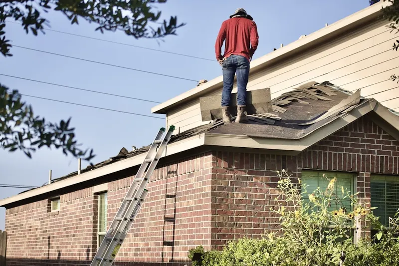 Professional roofer working on a residential roof in Newfane
